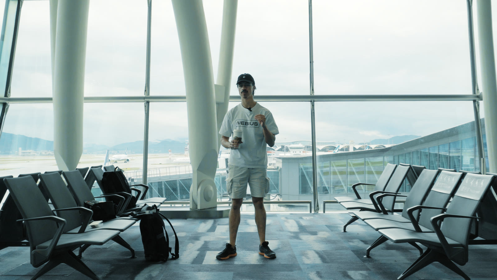 The same airport gate through the Bold Cinema LUT: teal glass and dark seats, clouds that keep their texture, a clean white T-shirt and natural skin