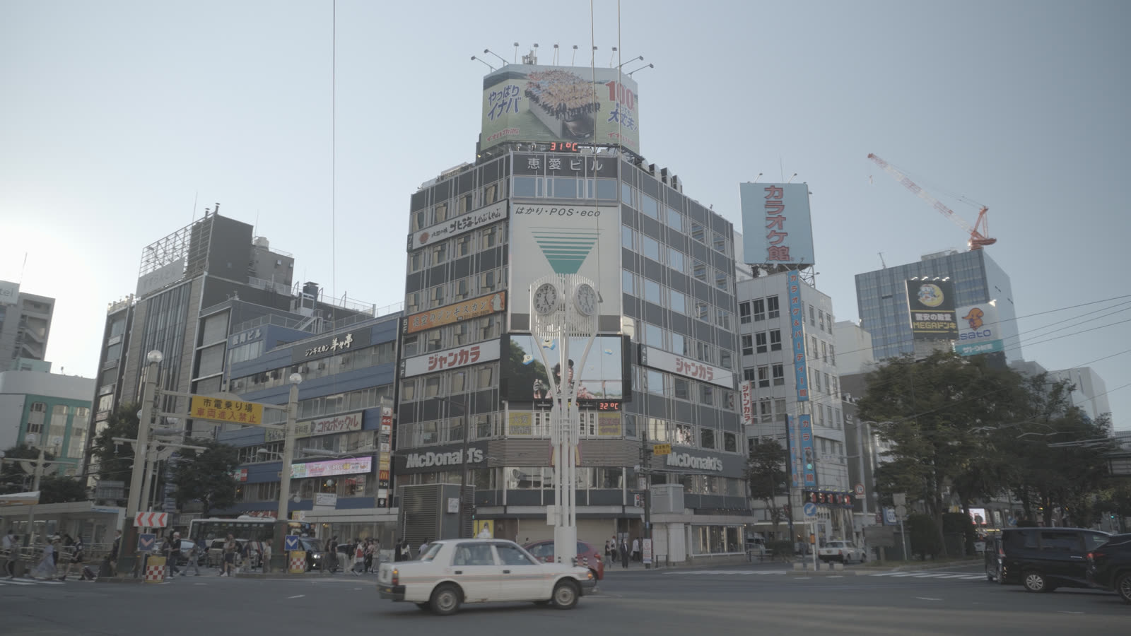 Ungraded log footage of a Sapporo intersection: flat, washed out, gray sky